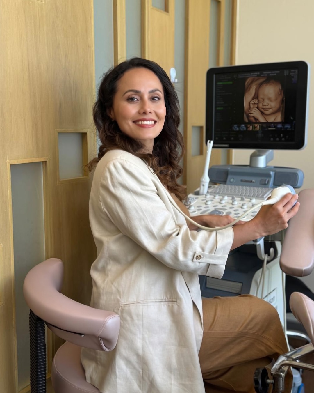 Dra. Gheidy Chinchilla sonriendo en su consultorio junto al equipo de ultrasonido